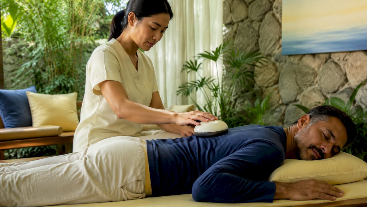 Therapist applying 40 Hz device to patient's back]